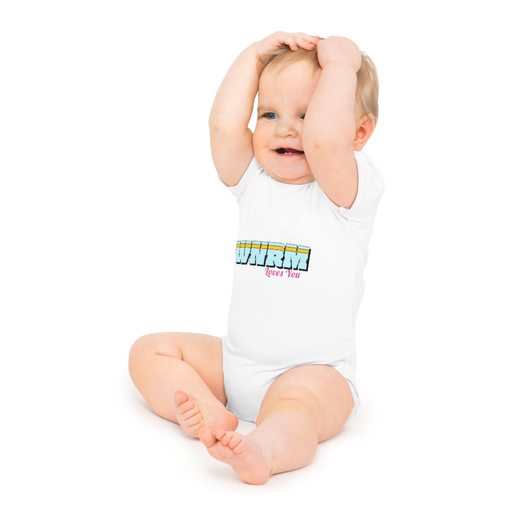 Cute baby with hands on heads wearing  a WNRM Loves You Baby Short Sleeve Bodysuit  white, with a white background