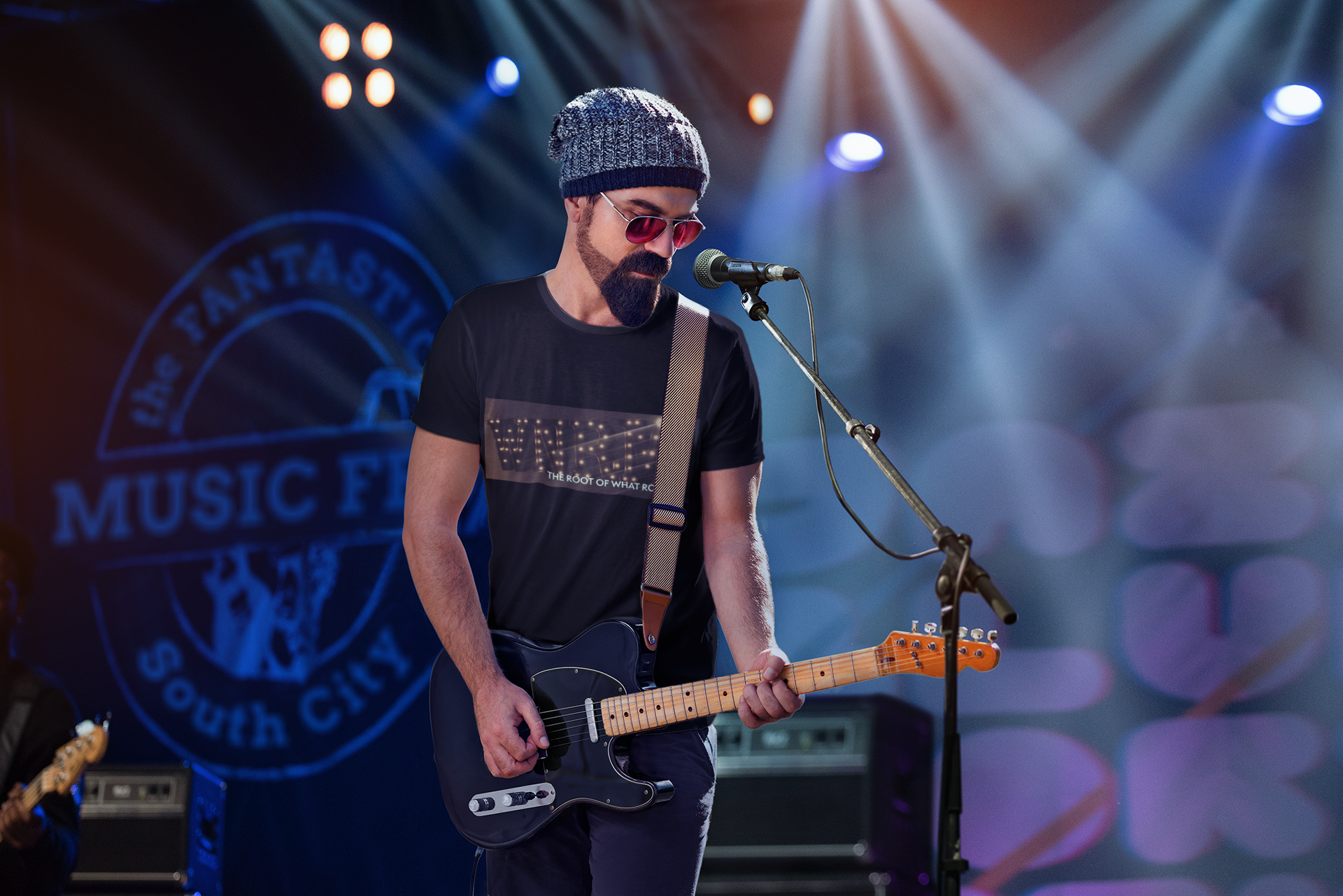 Musician wearing a WNRM Name In Lights Tee while playing guitar on stage under the spolights