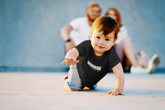 Cute baby wearing a WNRM Loves You Tee while crawling away from blue wall