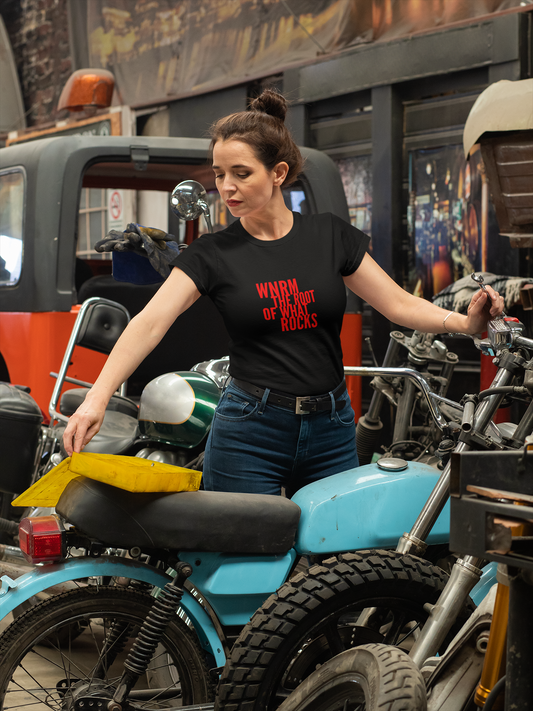 Woman wearing a OG WNRM Logo Tee while getting on a blue motorcycle