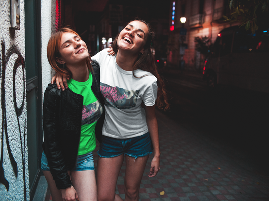 Party girls wearing a WWW Women's Softstyle Tee, in front of graffiti